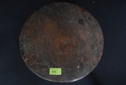 A 20th century Indian carved wooden circular chipati board raised on feet to edges