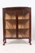 A 1940's sunburst effect oak display cabinet having astragal sunrise style glass door with lined