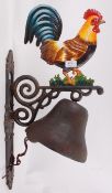 A large cast iron exterior wall hanging bell, on bracket,