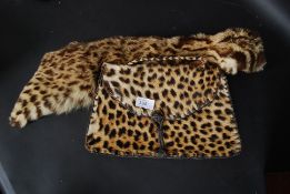 A taxidermy Leopard skin clutch bag owned by Audrey Lewis Hopkins along with a matching scarf.