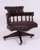 An antique style mahogany and oxblood red leather office captains swivel base raised on quadruped