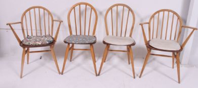 A set of 4 1970's vintage Ercol hoop back dining chairs raised on turned legs with panel seats and