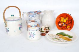 A Poole Pottery biscuit barrel together with a Poole Pottery jug, Delphis style dish,