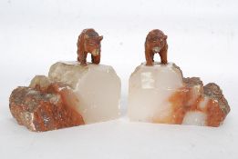 A pair of cold painted cast metal bear bookends mounted on marble plinths