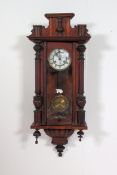 A 20th century wall clock with glazed front and carved wooden case, with enamel face.