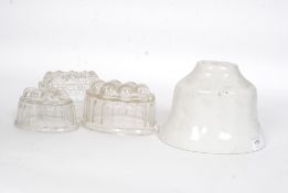A Victorian ceramic jelly mould along with three mid 20th century glass moulds