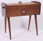 A vintage 1950's retro cantilever / metamorphic sewing box raised on tapered supports having