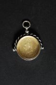 A silver hallmarked coin fob with enamel painted crest to verso.
