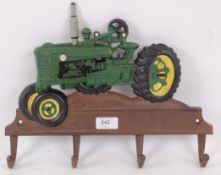A vintage style cast iron coat / cup rack in the form of an old tractor.