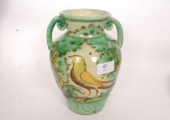 A decorative continental faience twin handled vase having exotic bird motif.
