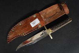 A stag horn handled bowie knife complete with the leather scabbard,