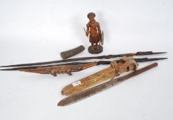 A collection of tribal art to include hardwood spears, machete, carved figurine of a warrior,
