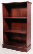 An antique style mahogany open window bookcase cabinet having central shelves with flared cornice