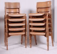 A stack of 10 retro 1950's ply panel wood Industrial school chairs raised on bentwood legs with