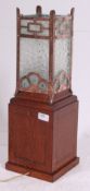 An Edwardian oak glass table lamp having fitted square copper and frosted glass shade atop over the