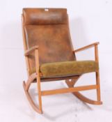 A Danish style teak wood rocking chair of angular form with padded seat and back rest in the manner