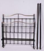 An Edwardian cast iron double bed with squared supports having rococo styled top rail with bed