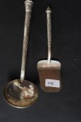 A Siam white metal ladle together with a matching cake slice being cast in repousse with chase