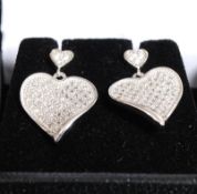 A pair of white metal 925 silver and CZ heart shaped earrings.
