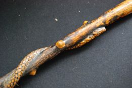 A vintage wooden walking stick, possibly blackwood having carved snake to the tapering stem.