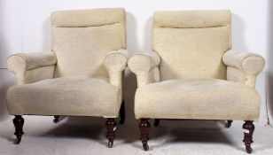 A pair of Victorian mahogany Chesterfield armchairs being raised on turned legs with brass castors