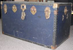 A vintage large steamer trunk with hinged top and clasps to front having brass bound corners etc