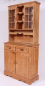 A 20th century antique style pine welsh dresser having a series of drawers and cupboards with