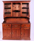 A 20th century contemporary pine dresser having a series of cupboards and drawers with upright top