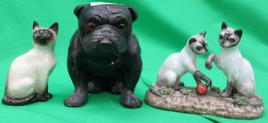 An ebonised ceramic bulldog with glass e