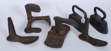 A collection of cobblers shoe stay's along with a couple of vintage cast irons