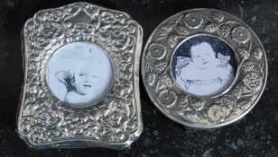 Two Victorian style silver plated photograph frames of rococo design, one being circular,