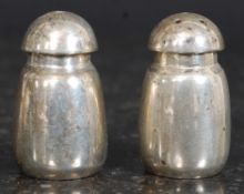 Two Sterling silver 20th century salt/pepper condiments having mushroom style tops and body.