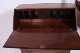 A 19th century mahogany Georgian country oak bureau desk raised on bracket feet with fully