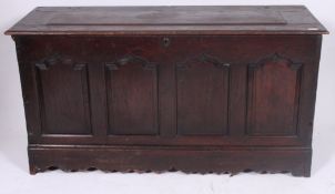 A 19th century large country oak coffer chest having detailed fielded panel front with hinged top