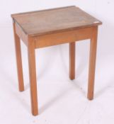 A vintage 1950's mid 20th century school desk with hinged top raised on squared supports.