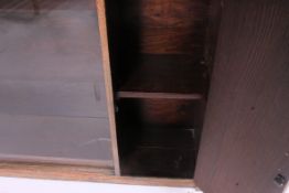 A mid 20th century oak lawyers bookcase cabinet having sliding glass bookcase with cupboard to the