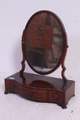 A 19th century mahogany swing mirror mounted above a three drawer serpentine base.