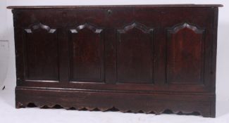 A 19th century large country oak coffer chest having detailed fielded panel front with hinged top
