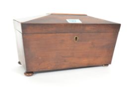 A 19th century mahogany sarcophagus shaped tea caddy with hinged top having sectioned caddy
