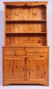 A 20th century pine welsh dresser having cupboards and drawers to the base with upright plate rack