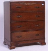 A 1930's Art Deco oak straight four chest of drawers being raised on bracket support feet with