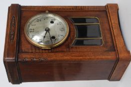 An oak cased 1930's mantle clock, brass face with eight day movement striking on a coiled spring.