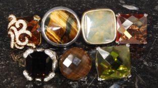 A collection of 7 white metal and yellow metal oversized ladies dress rings.