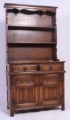 A Jaycee / Old Charm oak Gothic revival dresser having carved linen fold door cupboards under short