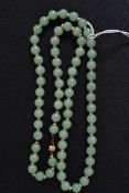 A malachite matching necklace and earrings set, along with a carved oriental jade necklace.