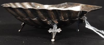 A continental silver butter shell raised on crucifix shaped supports bearing illegible markings.