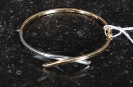 A ladies 9ct yellow and white gold contemporary cross over bracelet. Total weight 6.