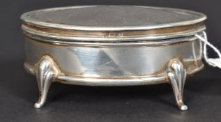 A silver hallmarked lozenge shaped ladies pill box on shaped legs with hinged top having central