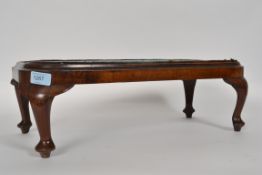 A Georgian 19th century beadwork topped maohgany footstool standing on cabriole legs with hoof feet