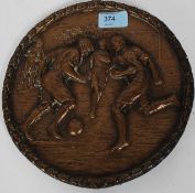 A fine quality bronze plaque cast in relief depicting football players having a a gadrooned border